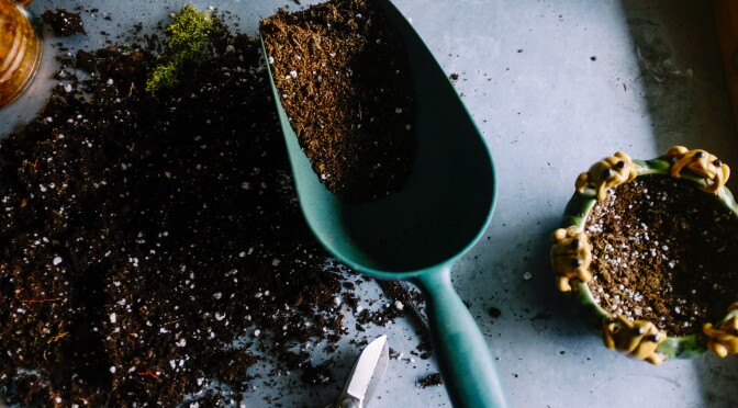 Een schepje met aarde gebruikt voor tuinonderhoud